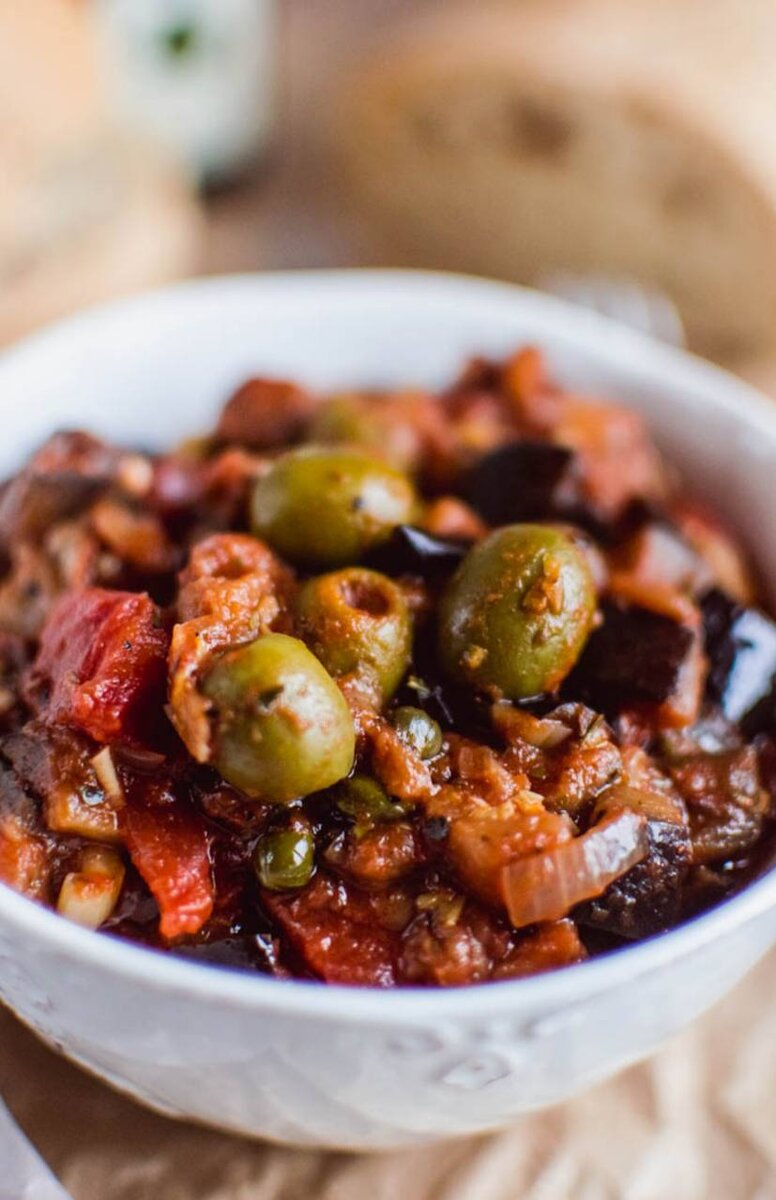 Ингредиенты:
2 средних баклажана
1 средняя луковица
2 зубчика чеснока
пучок петрушки
горсть оливок без косточки
2 ст.л. каперсов
2-3 ст.л. винного уксуса
томаты в собственном соку 425 мл
1 ч.л. сушеного орегано
соль, перец