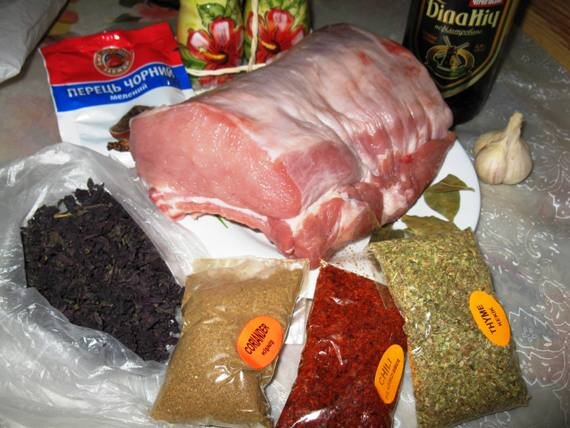 Подготовим  все продукты для приготовления свинины в мультиварке. Свинину нужно  покупать на рынке свежую, красивую и с приятным запахом. Я купила  отбивную, подойдёт любая филейная часть, можно и с жирком, кто какую  любит. Специи тоже могут быть на ваш вкус, но я не представляю свинину  без кориандра и базилика. Именно специи делают аромат блюда.
 
 Мясо нужно помыть, протереть насухо салфеткой, начинить свинину  чесноком, то есть сделать глубокие надрезы в куске и всунуть в них  очищенный чеснок.