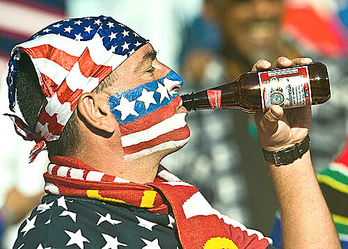 Житель США пьет пиво из стеклянной бутылки 