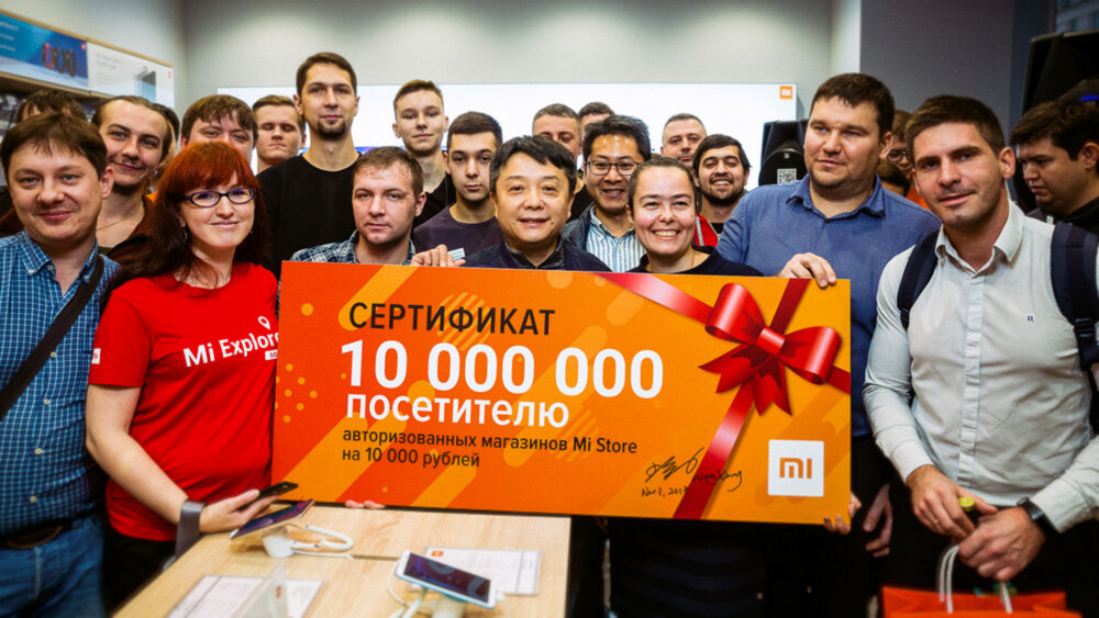 Строго  по центру — старший вице-президент компании Xiaomi, Ван Сянь. Справа от  него на переднем плане — представитель RDC Group Татьяна Арутюнова и  юбилейный покупатель Денис Мельников.