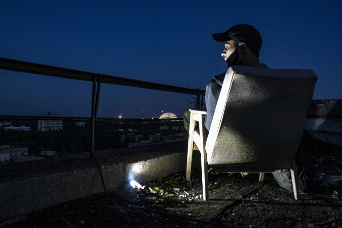 Сталкер на крыше дома в Припяти ночью