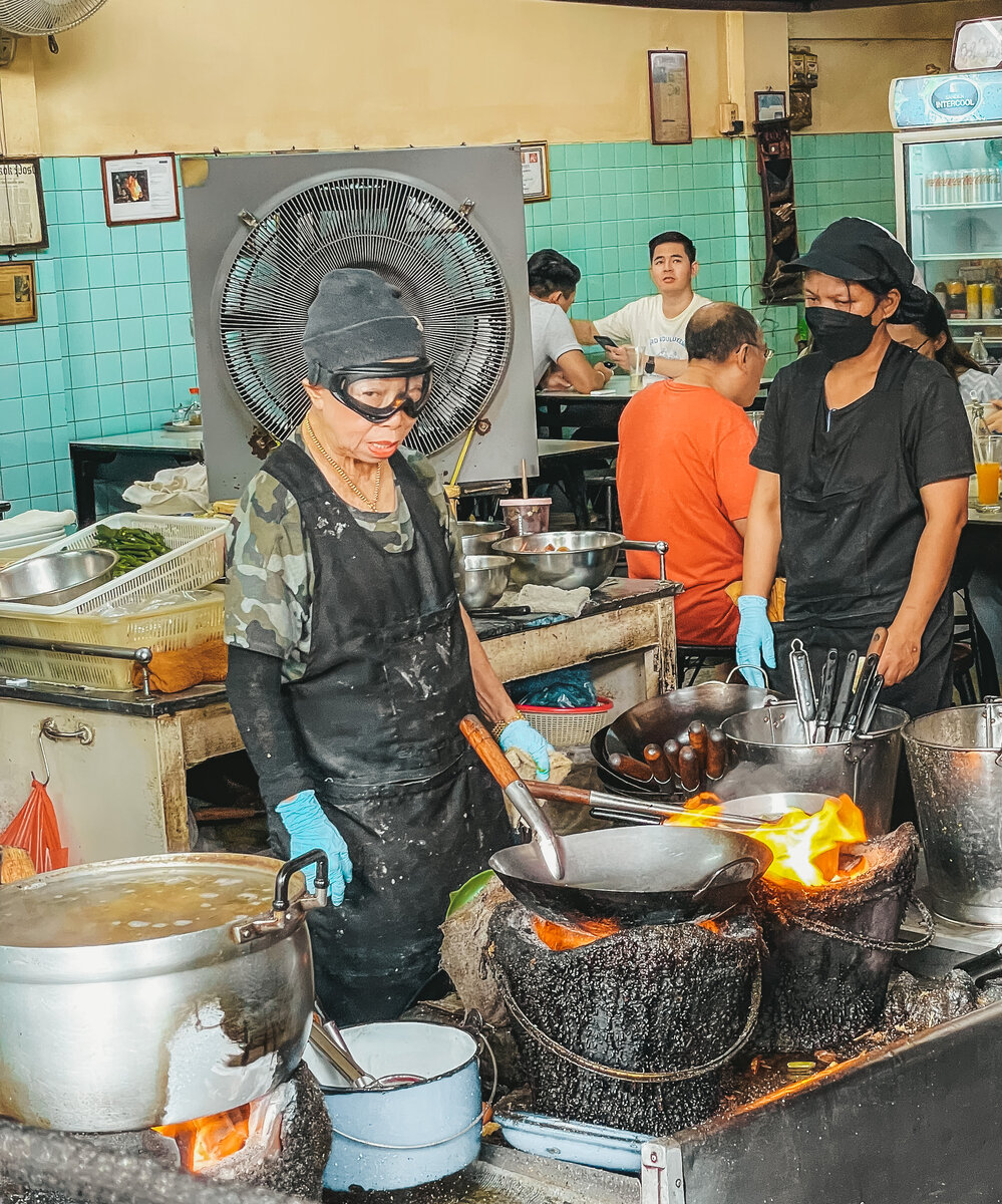 Выглядит бабуля весьма эксцентрично: в лыжной маске, вязаной шапке и с толстой золотой цепью на шее. Сразу видно, что живет точно не на пенсию.
