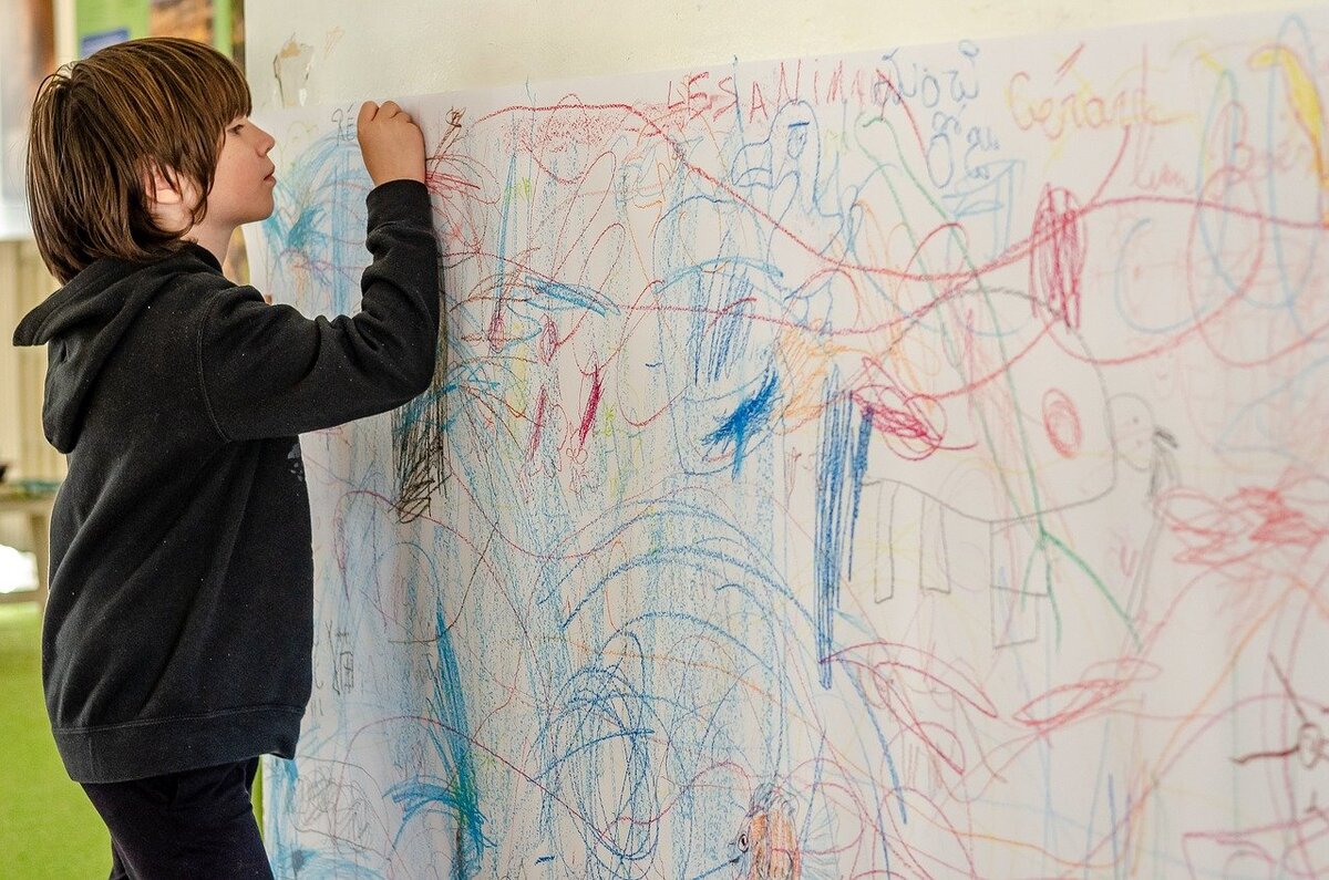 Мальчик рисует на стене