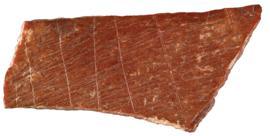 Около большого пальца этот гравированный фрагмент кости - один из пары, недавно обнаруженных в восточном Китае. Офорты смещают дату таких абстрактных рисунков в этом регионе на десятки тысяч лет.