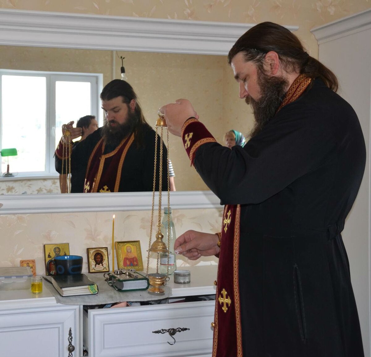 Священник освящает квартиру