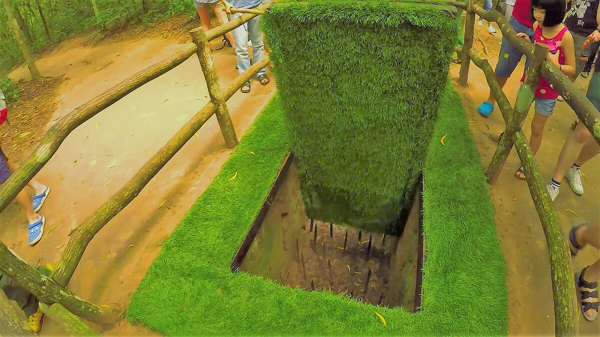 ловушка замаскирована травой, внизу острые железные пики >>>>