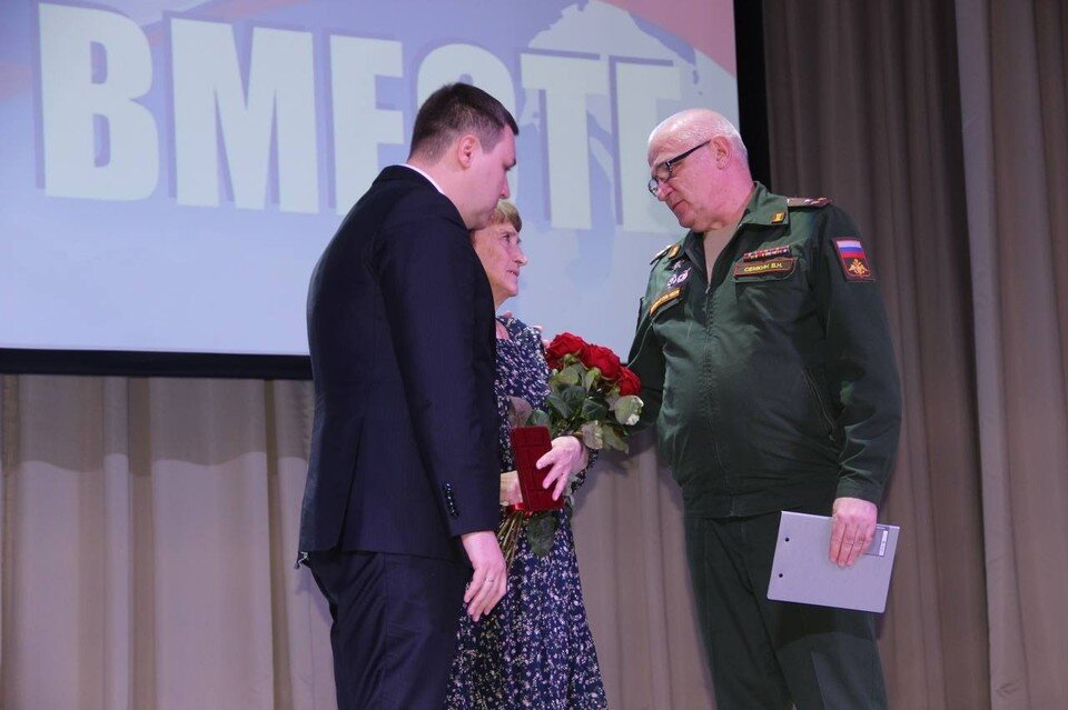     Глава города Владимир Песков совместно с военным комиссаром Вячеславом Семкиным передал орден Мужества маме Максима Сухарева на митинге-концерте в поддержку российских солдат. Фото: Администрация Бузулука