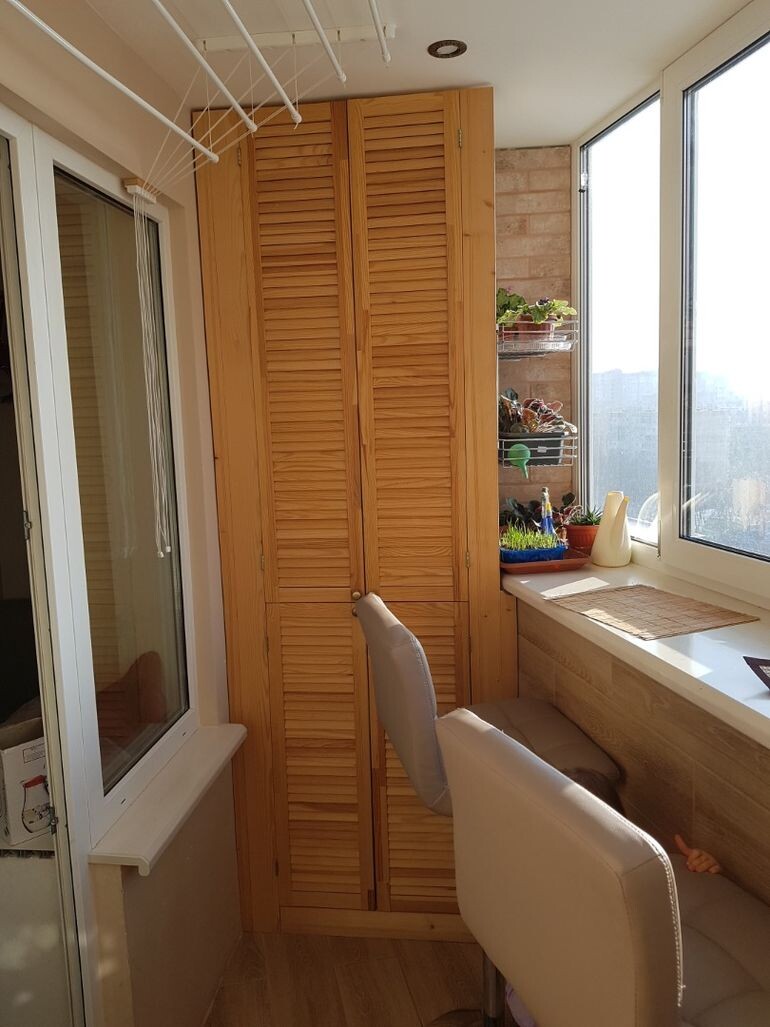 Правая стена акцентная, здесь впоследствии планирую полки с цветами. Слева установили вместительный шкаф с деревянными дверцами в тон отделке лоджии. Его намеренно не расширяли до самого окна, чтоб не потерять ширину, ощущение воздушности и не уменьшать доступ света в комнату. Эта ниша и декоративная и функциональная одновременно. Здесь размещены цветы, в том числе и на установленном карго, что облегчает уход за ними.