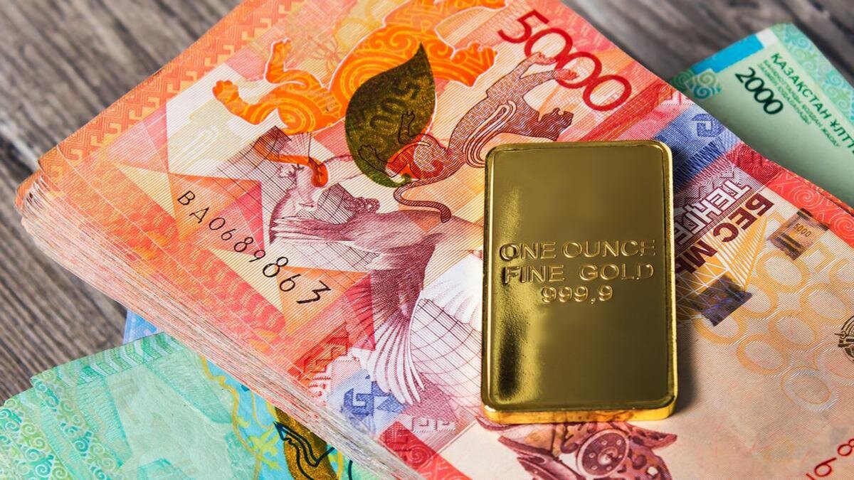    Золотой слиток лежит на пачке денег:Yevgeniy Sambulov/Getty Images