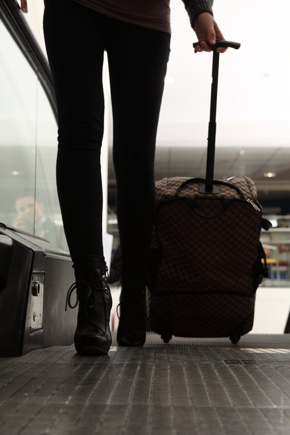 Девушка с чемоданом со спины