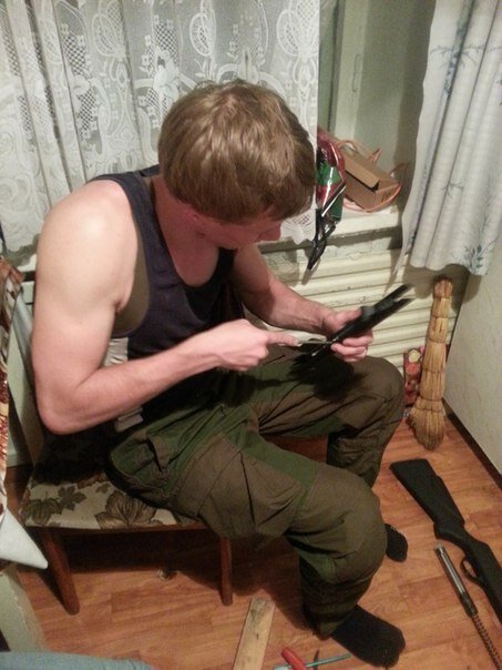 Сидеть разбор. В кресле с ружьем. Человек сидит разбирает ружье. Положил винтовку на коленки. Фото винтовок на ковре.