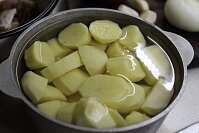 Прежде всего следует очистить небольшие картофелины, промыть корнеплоды и нарезать крупными кружочками. Залить картошку водой и отправить вариться до полуготовности в подсоленной воде.