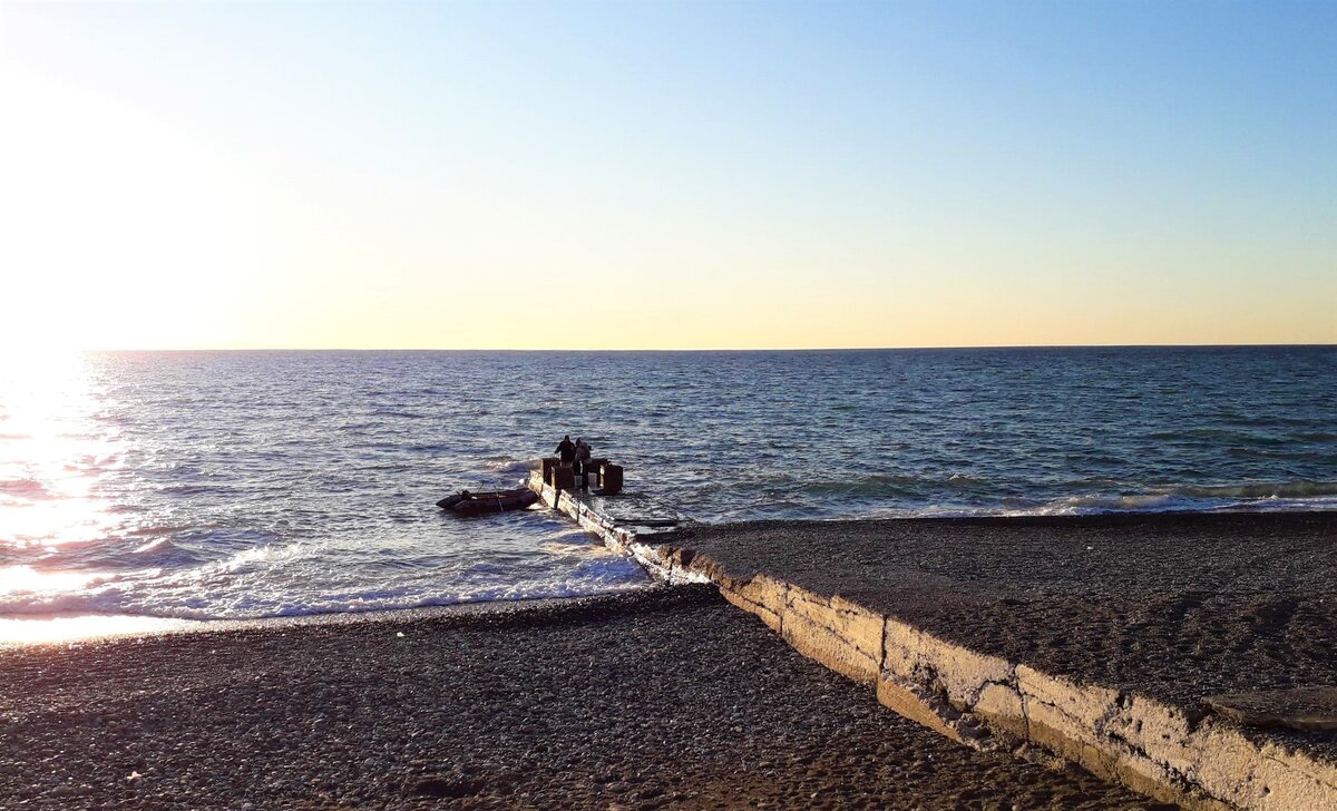 Рыбаки высаживаются на волнорез. 