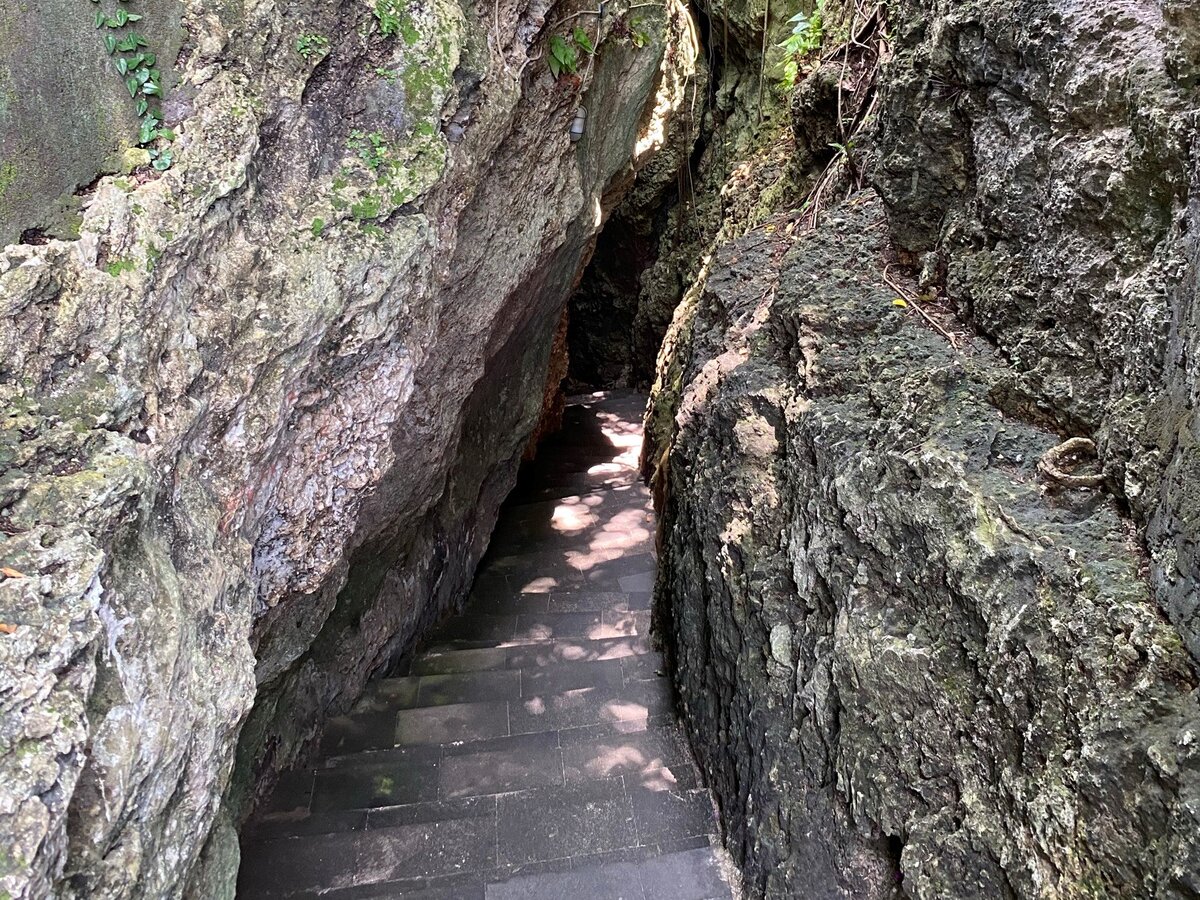 Чтобы попасть на пляж, сначала нужно спуститься по ступенькам в узком ущелье 