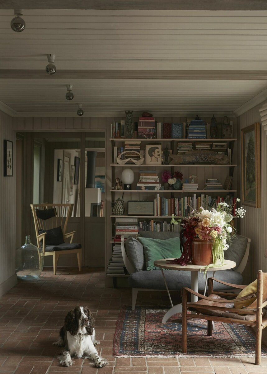 Из прихожей гости сразу попадают в небольшую гостиную с мини-библиотекой. Каменные полы (кстати, это редкость для Швеции), старый ковер (почти как у нас в 90-х), роскошный букет садовых цветов в старенькой глиняной вазе... Люблю «чужие», непривычные нам интерьеры, именно за обилие деталей, которые можно разглядывать долго-долго