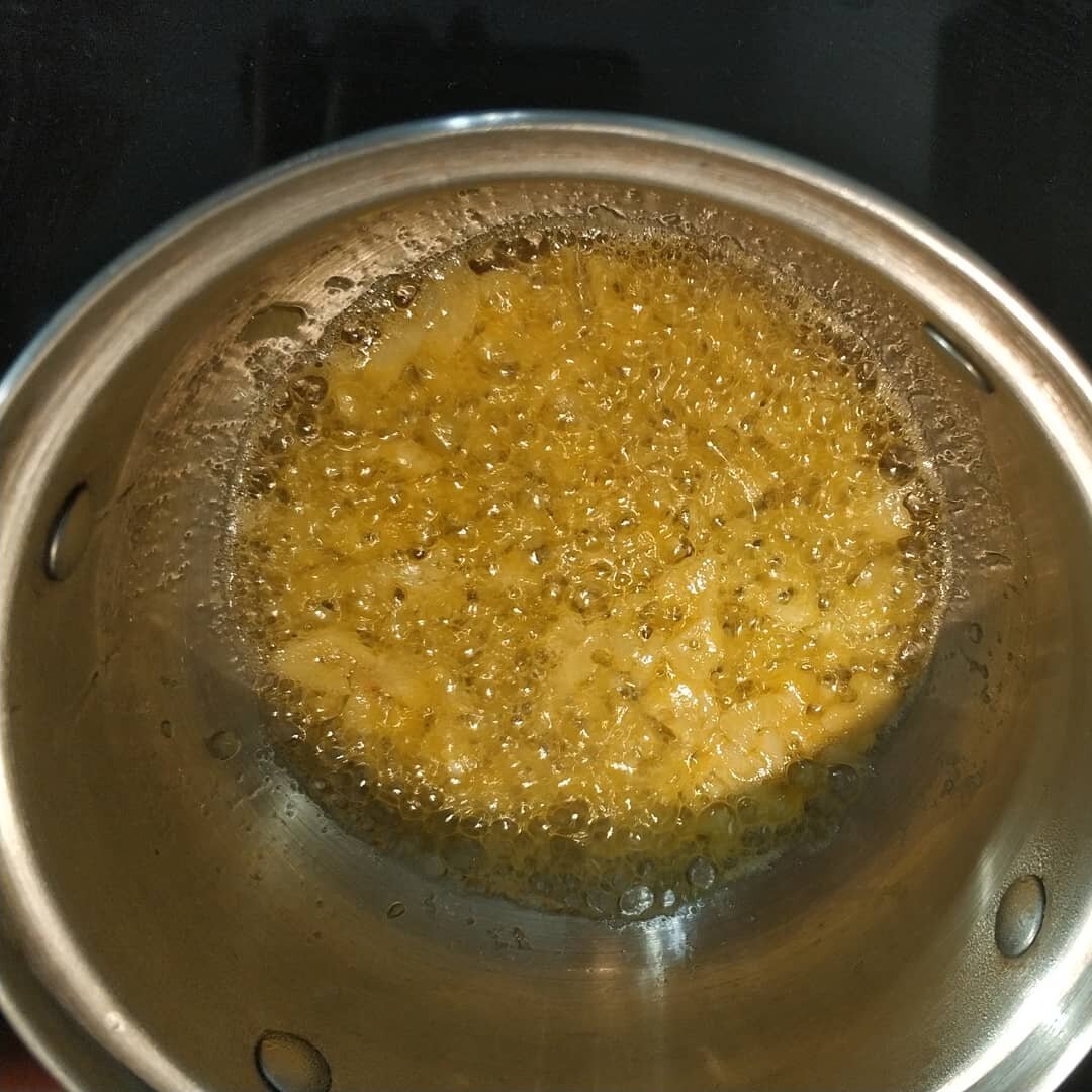 Лук и чеснок порезать кубиками и поджарить в кастрюле на растительном масле до золотистого цвета.