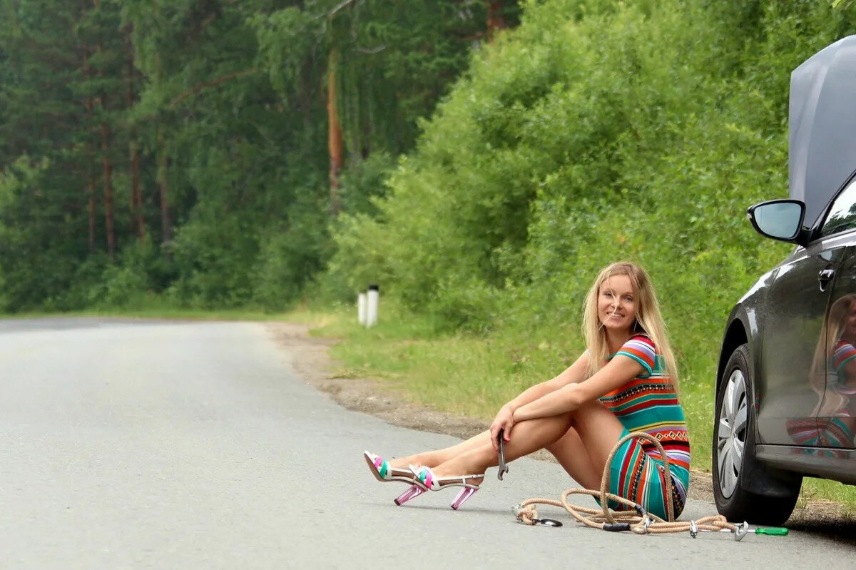 Даже девушки чинят автомобиль на трассе