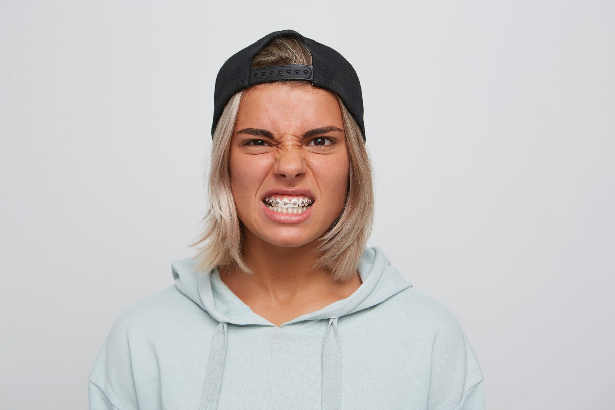 <a href="https://ru.freepik.com/free-photo/portrait-of-mad-angry-blonde-young-woman-with-braces-on-teeth-wears-black-cap-and-hoodie-looks-irritated-and-furious-isolated-over-white-wall_10625837.htm#query=%D1%87%D0%B5%D0%BB%D0%BE%D0%B2%D0%B5%D0%BA%20%D1%81%20%D1%81%D0%B6%D0%B0%D1%82%D0%BE%D0%B9%20%D1%87%D0%B5%D0%BB%D1%8E%D1%81%D1%82%D1%8C%D1%8E&position=6&from_view=search&track=ais">Изображение от nakaridore</a> на Freepik