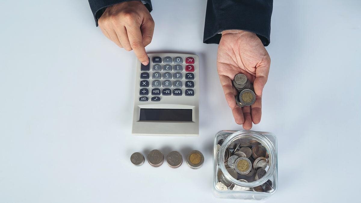    Банка с деньгами и калькулятор лежат на столе:freepik.com/jcomp