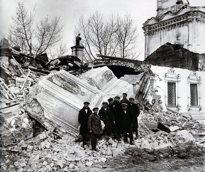 Коммунисты фотографируются на память у разрушенной церкви.