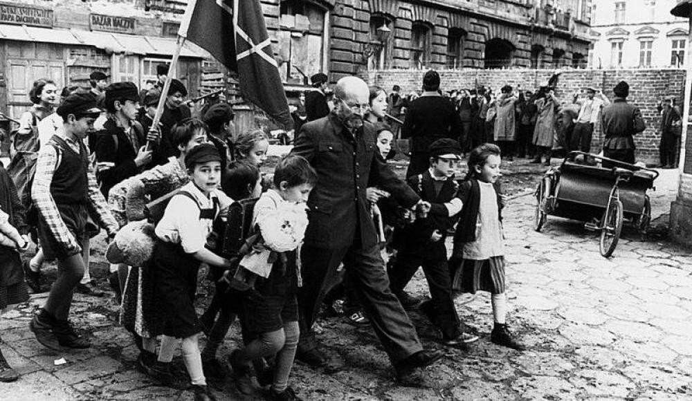 Воспитанники Дома Сирот во главе со Старым Доктором, с флагом, выходят из здания