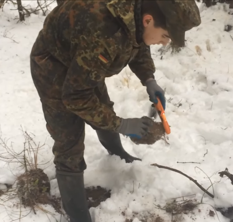 Вот в этой грудке земли мы нашли пуговицу.