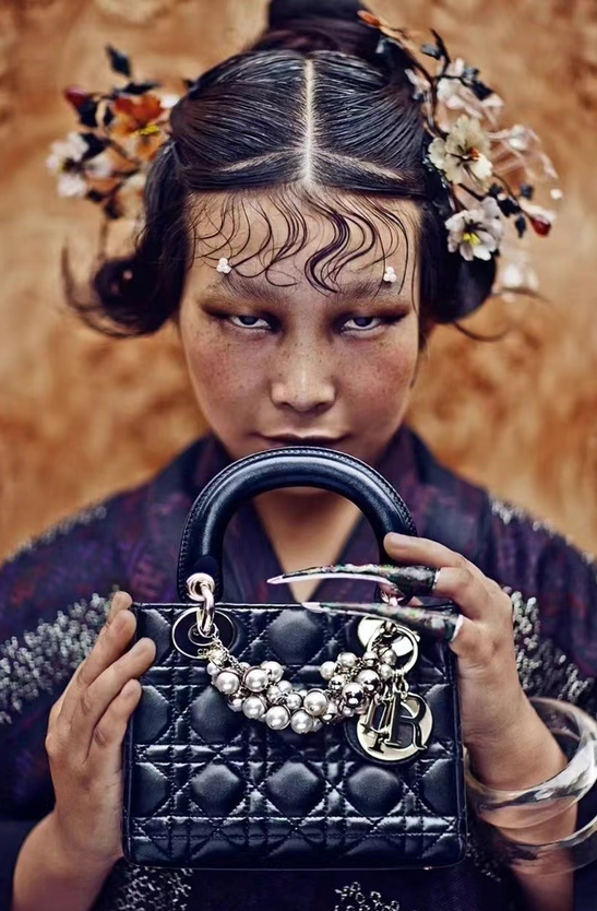 В середине ноября в Китае опубликовали фотографию рекламной кампании модного дома Диор в "китайском стиле". На снимке девушка азиатской внешности, в традиционном костюме и с брендовой сумочкой в руках.-2