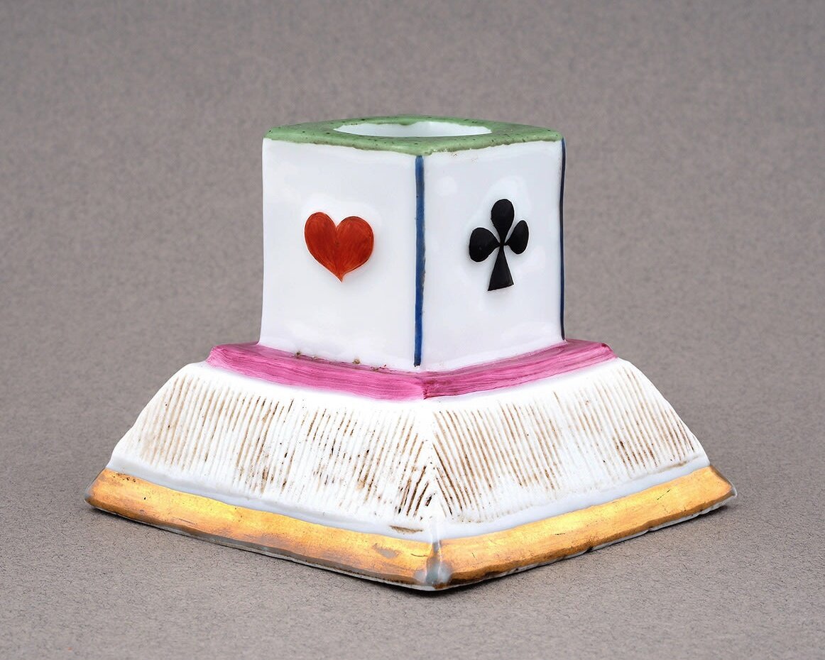 Подсвечник "Карты" фабрика Товарищества М.С. Кузнецова в Дулеве. 1870-90-е годы, 
Фарфор, роспись, золочение. Высота 7 см. https://ru.bidspirit.com/