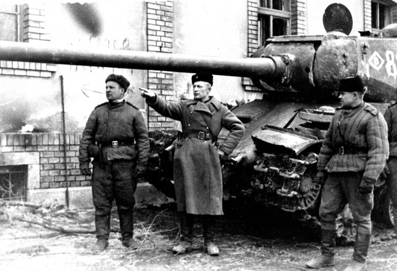 Советские командиры возле тяжелого танка ИС-2 на улице города в Европе. 1944—1945 гг. 
