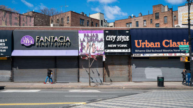 Пешеходы проходят мимо закрытых магазинов на Фордхэм-роуд в Бронксе, Нью-Йорк, 2 апреля 2020 года. Дэвид Ди Дельгадо | Bloomberg через Getty Images