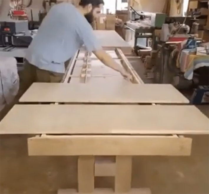 Демонстрируется длинный раздвижной стол на стадии его изготовления