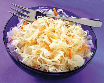 Нашинкуй средних размеров головку капусты. Натри на терке пару морковок, руками хорошо перемешай ее с капустой. Теперь возьми ведро, налей в него 8 литров чисто (лучше отстоянной) воды и насыпь 800 граммов соли. В этот рассол маленькими порциями всыпь капусту с морковью, дай настояться в течение 5 минут. Отожми продукты и разложи в чистые стеклянные банки, придави каждую порцию деревянным брусочком. Плотно закрой банки капроновыми крышками и храни в холодном месте – например, на балконе.