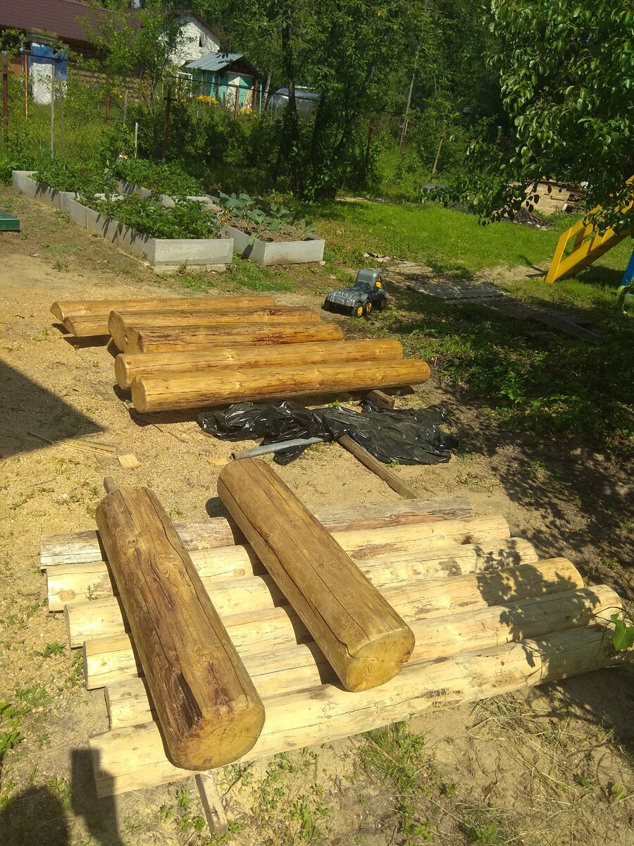 Бревна в процессе покрытия лаком