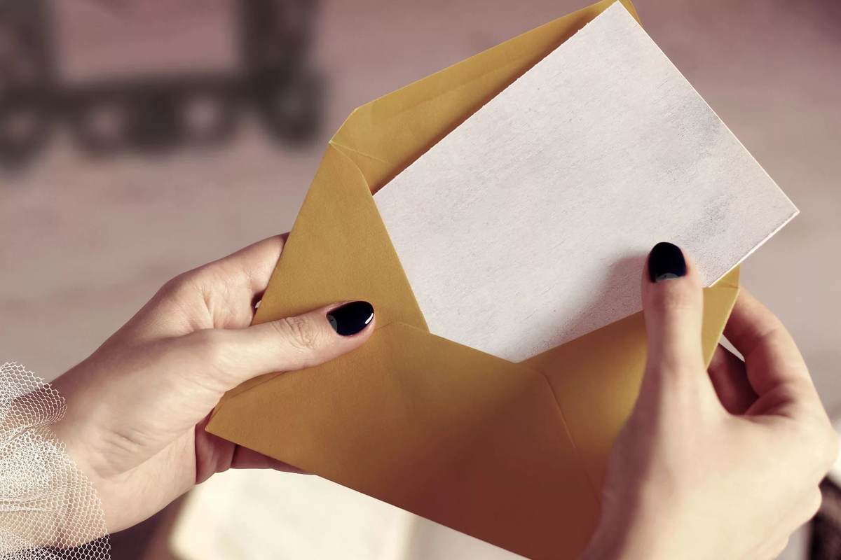 Конверт в руках. Девушка с конвертом в руках. Открытый конверт в руках. Рука передает конверт.