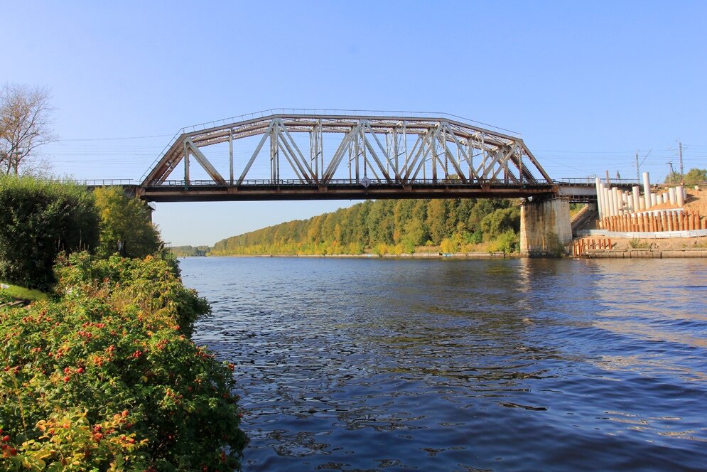 1. Вид на существующий Хлебниковский мост Савёловского хода через Канал имени Москвы. Он был сооружён в 1934-1936 годах при строительстве канала вместе с другим железнодорожным мостом этой же дороги, расположенном в районе посёлка Деденёво, между платформой Турист и станцией Яхрома. По своей конструкции мост однопролётный. Ширина пролёта — 100 метров, ширина судового хода в пролёте — 80 метров, высота пролёта в пределах судового хода — 14 метров от НПУ. Мост неохраняемый, проход пешеходов по мосту возможен с обеих сторон (но из-за частого движения поездов сопряжён с риском, поэтому надо помнить об осторожности!).