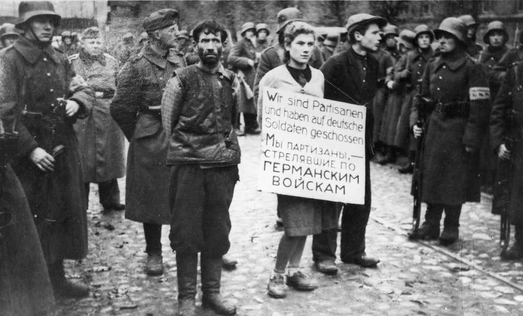 На щите надпись на немецком и русском языках: «Мы партизаны, стрелявшие по германским войскам»