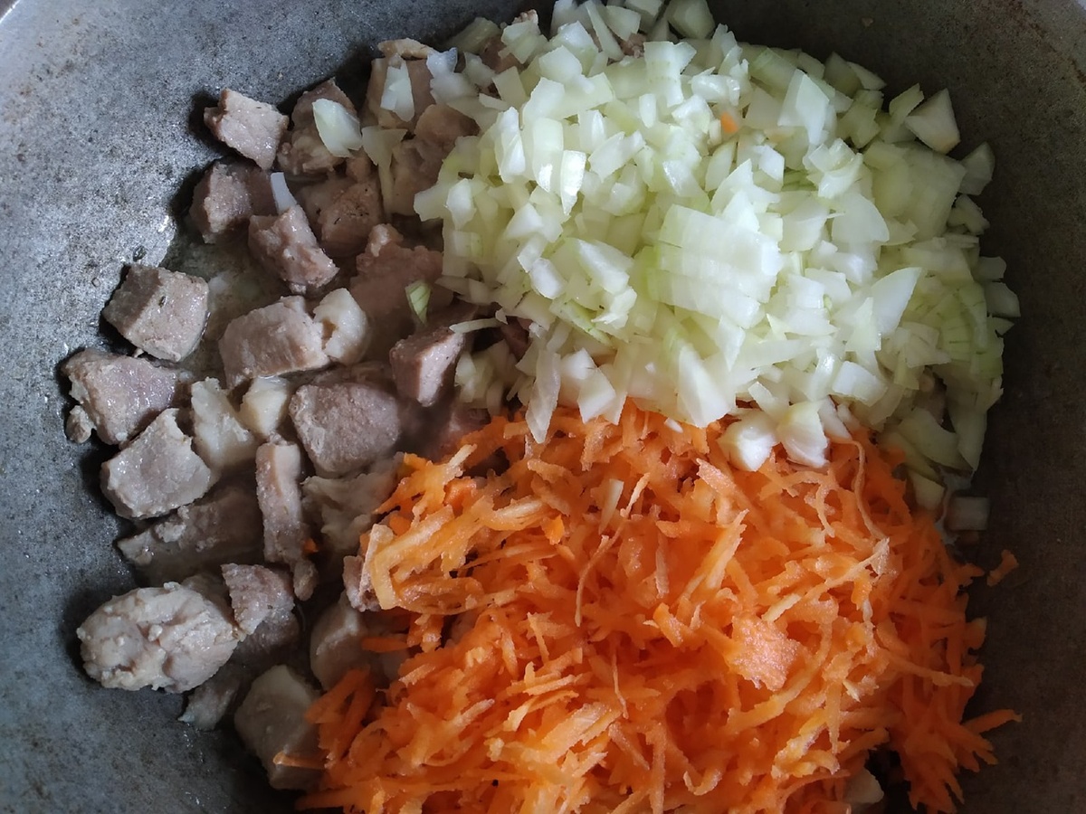 Добавляем лук, нарезанный кубиками, морковь - натертую на терке. Перемешиваем и тушим 10 мин. Солим и перчим.