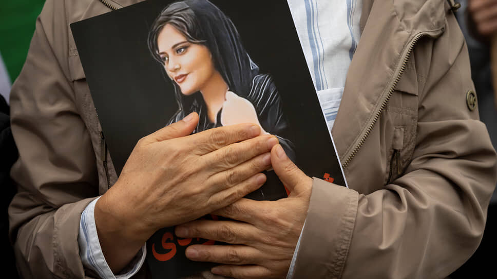 Фото: Cliff Owen / AP📷Участник протеста несет портрет Махсы Амини