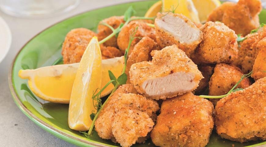 ИНГРЕДИЕНТЫ 500 г филе куриной грудки
4 ч. л. смеси сушеных итальянских трав
2 яйца
120 мл жирных сливок
2 стакана панировочных сухарей
1 стакан муки
растительное масло
соль
свежемолотый черный перец
лимон для подачи
ПОШАГОВЫЙ РЕЦЕПТ ПРИГОТОВЛЕНИЯ
Шаг 1
В большую кастрюлю (или фритюрницу) налейте растительное масло слоем 3,5 см и нагрейте его на сильном огне. Температура масла должна составлять 175 °С (если нет термометра, бросьте кубика хлеба, если он быстро зажарится до золотистого цвета, масло достаточно нагрето).
Шаг 2
Фото приготовления рецепта: Цыпленок по-милански для большой компании, шаг №2
Нарежьте куриное филе кубиками со стороной 2,5 см. Приправьте курицу солью и перцем, посыпьте 1 ч. л. пряных трав.
Шаг 3
Фото приготовления рецепта: Цыпленок по-милански для большой компании, шаг №3
В миске взбейте яйца со сливками и 1 ч. л. пряных трав.
Шаг 4
Фото приготовления рецепта: Цыпленок по-милански для большой компании, шаг №4
В другой миске смешайте сухари с еще 1 ч. л. пряных трав.
Шаг 5
В третью миску насыпьте муку и оставшуюся 1 ч. л. пряных трав. Подготовьте два противня, один застелите пергаментом, а другой бумажными полотенцами.
Шаг 6
Фото приготовления рецепта: Цыпленок по-милански для большой компании, шаг №6
Погружайте кусочки курицы в муку, стряхивайте излишки. Затем опускайте в яичную смесь, а потом обваливайте в сухарях. Перекладывайте на противень, покрытый пергаментом.
Шаг 7
Фото приготовления рецепта: Цыпленок по-милански для большой компании, шаг №7
Опускайте в горячее масло по несколько кусочков курицы и жарьте до готовности, 6–7 мин. Доставайте курицу шумовкой и перекладывайте на бумажные полотенца.
Шаг 8
Фото приготовления рецепта: Цыпленок по-милански для большой компании, шаг №8
Выложите курицу на блюдо и подавайте с дольками лимона.