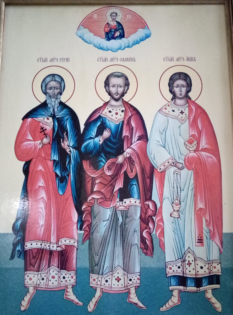 Икона "Святые мученики Гурий, Самон, Авива". Средняя колонна справа от центрального придела. Храм Успения Пресвятой Богородицы "за верхом" г. Калуга.  Они названы еврейскими именами. Гурий означат львенок, Самон – сильный, Авив – ячменный колосок и вместе с этим это название первого месяца еврейского календаря. Традиционно их изображают вместе:  Гурий — седовласый старец с длинной бородой, одет в хитон и гиматий;  Самон — среднего возраста с темными (иногда седыми волосами) и с небольшой бородой, одет в хитон и гиматий;  Авив — молодой безбородый человек в стихаре с кадилом и (или) крестом в руках.