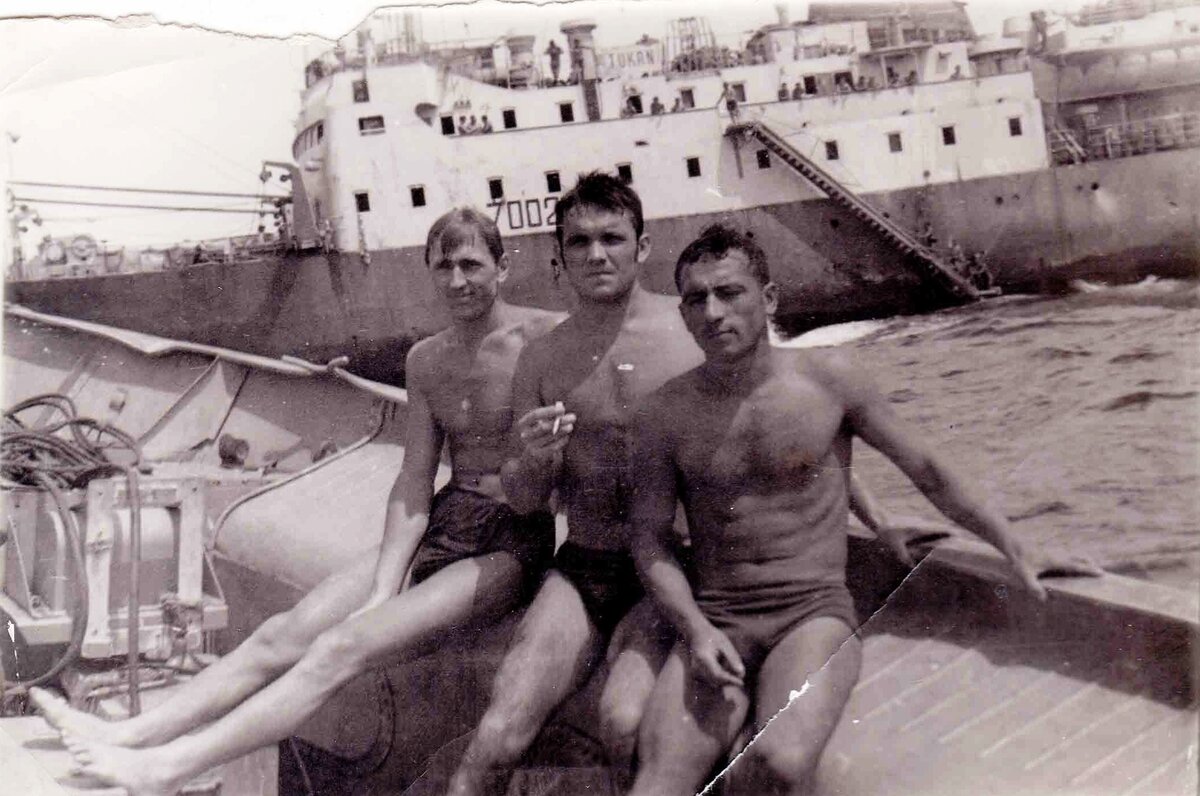 1965 год. Рулевой «Тукана» Павел Порхун (слева) с товарищами на фоне злополучного траулера. Несмотря на трагедию в 1967-м, с профессией Павел Михайлович не порвал, выучился на технолога и потом ещё почти три десятка лет бороздил моря-океаны