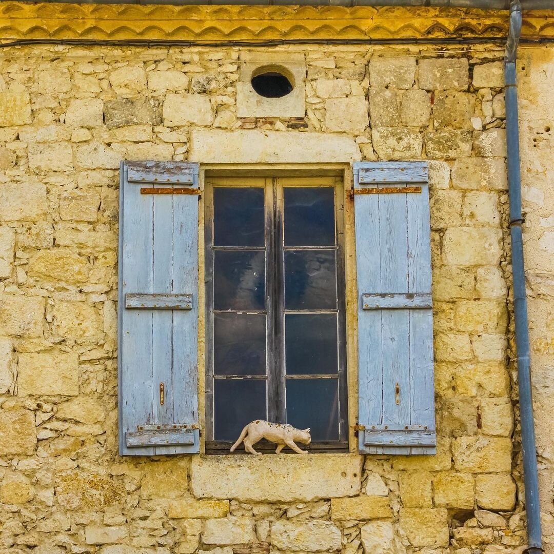 Скульптура кошки на окне