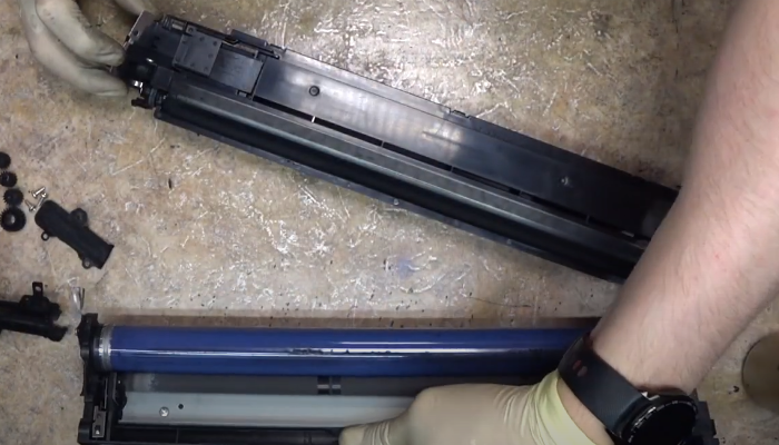 Фото 21. Две половины драм-картриджа. Вверху половина с магнитным роликом и девелопером. В этой половине блока фотобарабана смешивается тонер с девелопером. Внизу расположена половина с фотобарабаном, роликом заряда и ракелем. 