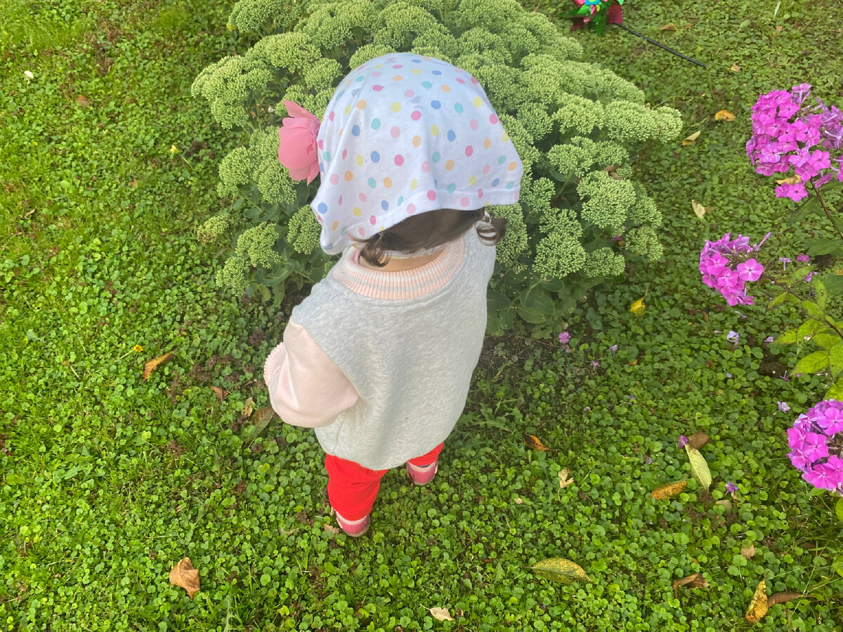 Дочка с радостью гуляет на дачном участке.