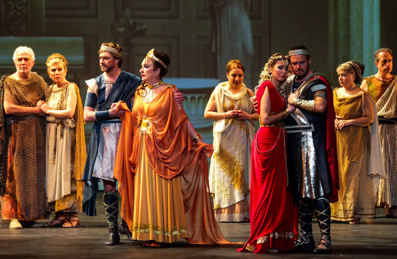 Тематический материал, который пытается разрабатывать композитор, основан на тюркском мелосе, турецком фольклоре. И этот парадокс вовсе не случаен — в буклете к опере режиссер спектакля Айылмаз и научный сотрудник Национального центра научных исследований Турции Халук Тарджан утверждают принадлежность троянцев к тюркам.