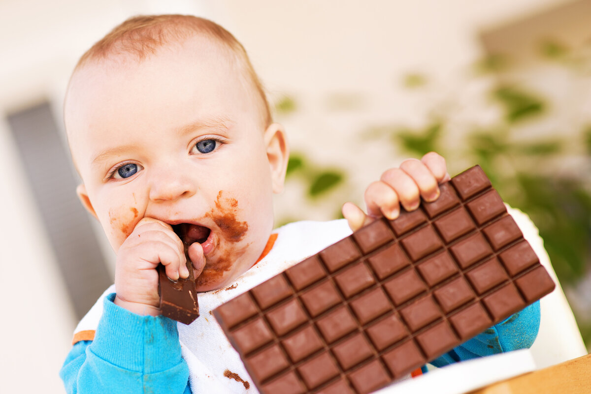 Есть конфеты повкуснее. Шоколадки для детей. Ребенок с огромной шоколадкой.
