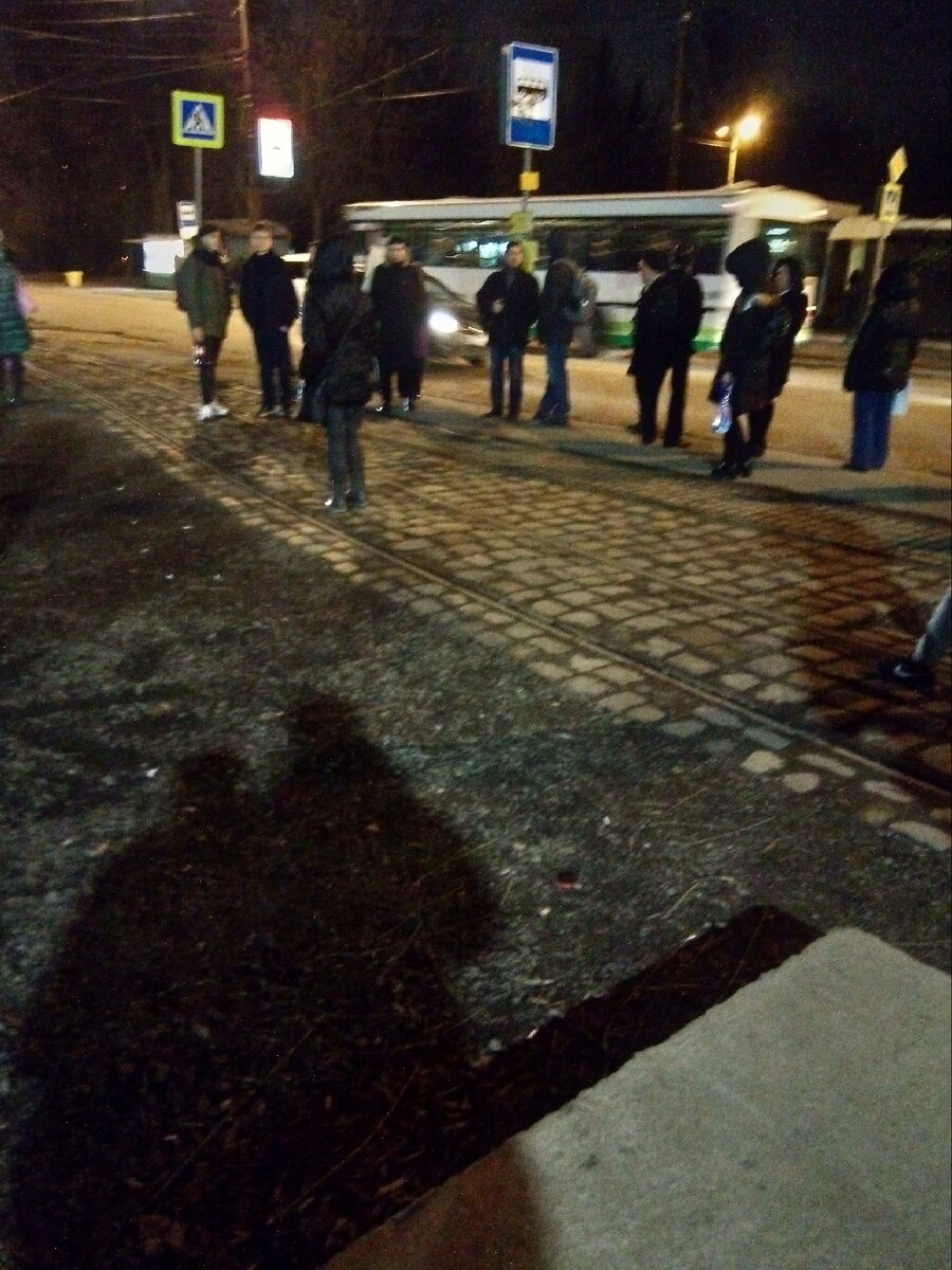 Это фото наглядно демонстрирует одну из причин, почему я не планирую в обозримом будущем отправлять Вику на занятия самостоятельно. Это остановка. Одновременно для трамваев в нашу сторону и автобусов — в противоположную. Расстояние от крайнего рельса до бордюра, за которым уже проезжая часть, составляет около метра. Когда подъезжает трамвай, людям, которые собираются на него сесть, уйти особо некуда. При этом в тот же момент может остановиться и автобус, откуда выходят люди. Не оказаться ни на рельсах, ни на проезжей части иногда сложно. В ожидании трамвая и автобуса многие стоят на трамвайных рельсах, поскольку стоя на остановке, мешаешь выходящим из автобуса. Чтобы не мешать, приходится или сдвигаться на те же рельсы, или уходить ещё дальше. На фото только ушёл трамвай, поэтому людей немного