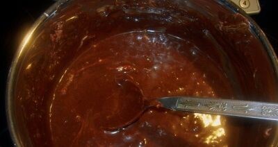 В отдельной посуде растопим, поломанную на мелкие кусочки плитку шоколада. Растапливаем на слабом огне, постоянно помещивая, чтоб не пригорело. Затем добавляем к нему маршмеллоу (это некий аналог пастилы, напоминает легкий зефир) и ждем пока растопится примерно половина.       Затем влить сливки и коньяк и добавить сливочное масло. Постоянно мешая, на слабом огне варим до получения густой однородной массы (7-8 минут).       По истечении вышеуказанного времени снимаем посуду с массой с огня и, опять же, постоянно помешивая, добавляем понемногу сахарную пудру. Когда масса загустеет до той степени, что ложкой уже невозможно будет перемешивать – делаем это рукой. Добавляем пудру до тех пор, пока масса не станем похожа эластичное и теплое тесто.  Вынимаем с кастрюли, перекладываем мастику на бумагу для выпечки и плотно заворачиваем.   