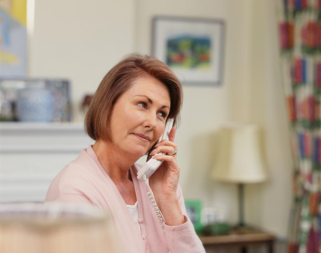 Сайт тетушек. Женщина среднего возраста. Разговор по домашнему телефону. Женщина средних лет разговаривает по телефону. Женщина в квартире с телефоном.
