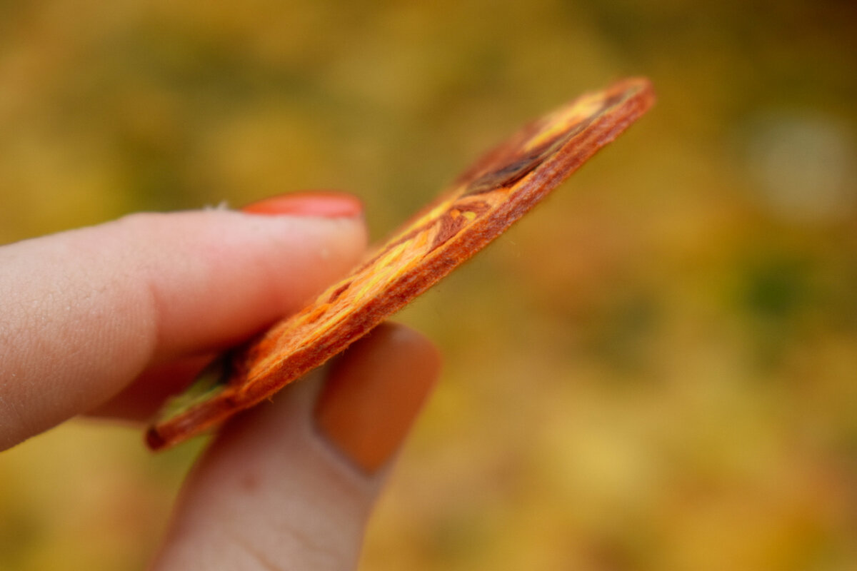 Вышивка и задняя часть склеены при помощи двухсторонней клеевой паутинки. Края обработаны паяльником и клеем.